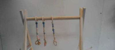 Photo of Folding wooden activity gym with three hanging toys