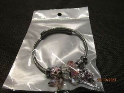 Photo of Silver metal coloured bracelet with charms